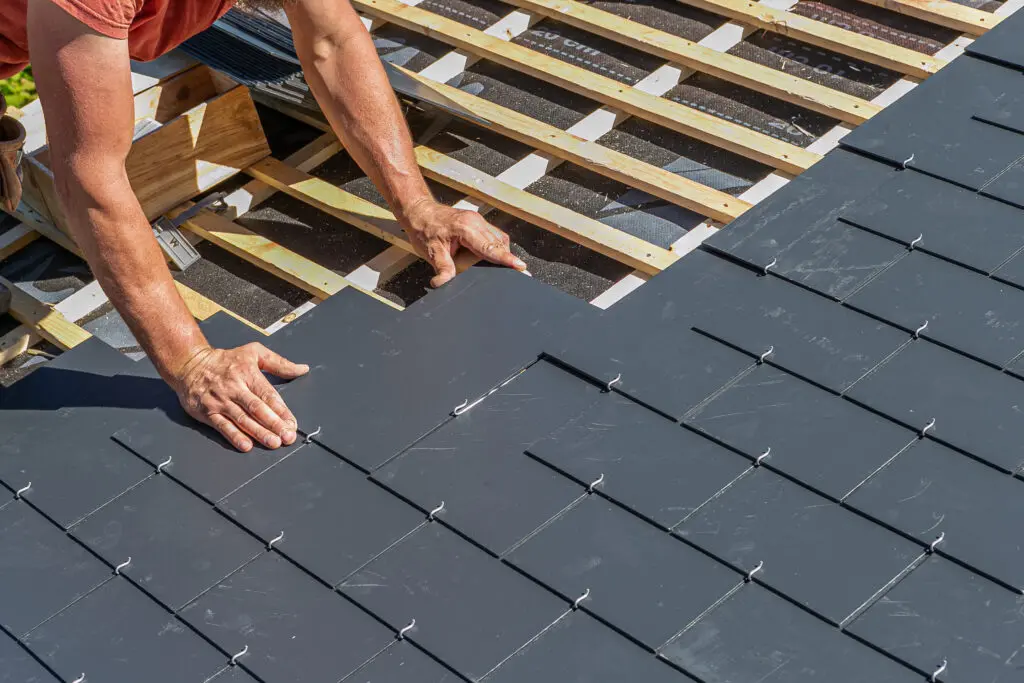 roofer installing roof shingles on decking during roof replacement