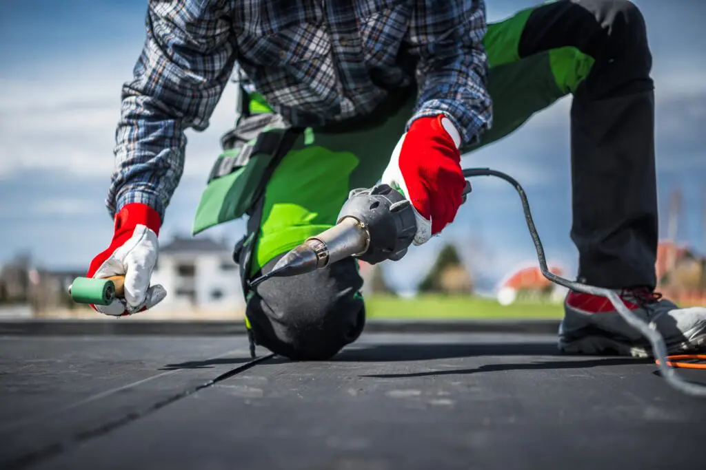 roofer installing flat roofing membrane system