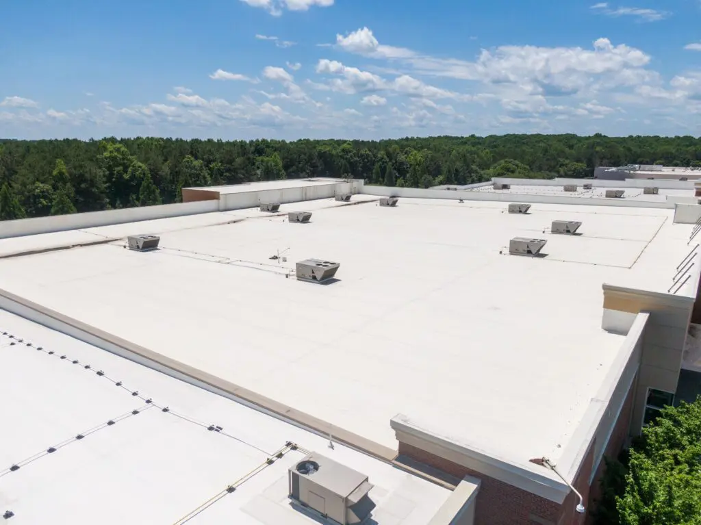 TPO roof repair and installation highlighting a white commercial flat roofing system on large building